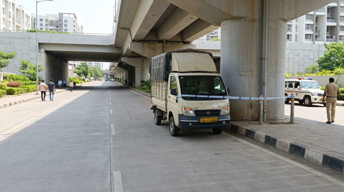 A white tempo is parked on the road under a flyover, with blue tape in front of it. A police officer stands nearby.